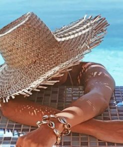 Woman In Swimming Pool In A Large Beige Sunhat